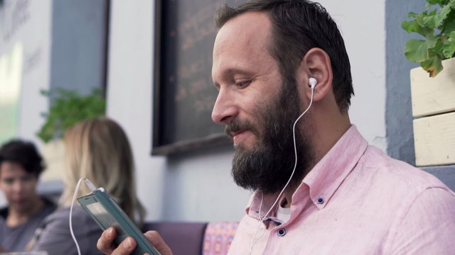 Man listening to music on smartphone in cafe in the city
