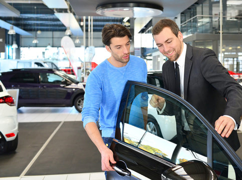 Verkaufsgespräch im Autohaus - Verkäufer berät Kunden beim Kauf eines Neuwagen // sales talk in the car trade 