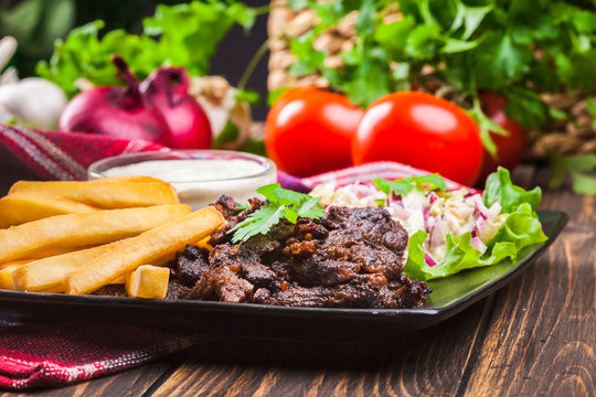 Kebab of beef with french fries and salad