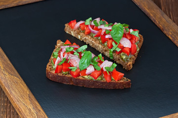 Bruschetta / Delicious tomato bruschetta with red onion, basil and pesto sauce