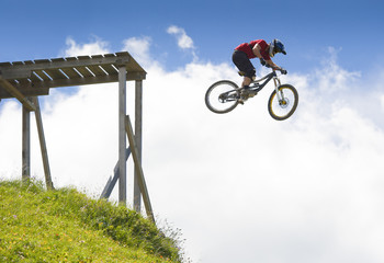 Mountainbiker jumping from a wood platform