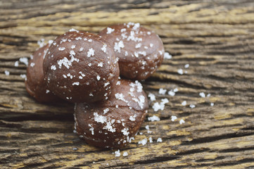 Small chocolate doughnuts on old wooden background