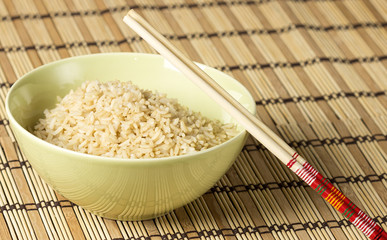 Boiled brown rice on bamboo washer with chopsticks