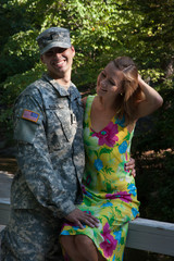 Fototapeta na wymiar Pretty woman and a soldier being romantic outdoors