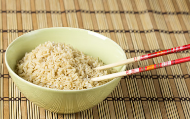 Boiled brown rice on bamboo washer with chopsticks