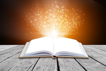 Opened magic book on abstract gold background