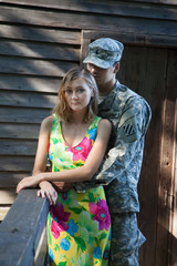 Pretty woman and a soldier being romantic outdoors