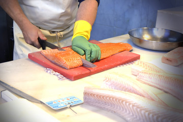 man cutting fish in a supermarket
