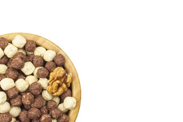 Chocolate cereal balls in a bowl of bamboo. Healthy breakfast with fruit and milk. A diet full of energy and fiber for athletes. Quick to prepare homemade breakfast. Isolated on white