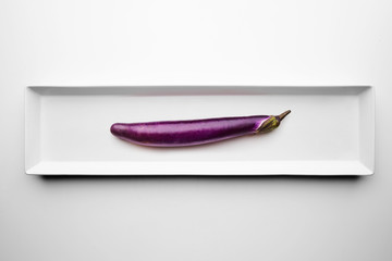 Long eggplant isolated on blank white plate