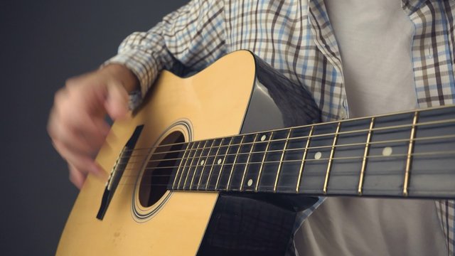 Man playing acoustic guitar, rock musician playing guitar, unplugged music performance