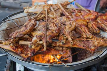 Grilling chicken plugged with bamboo, Thailand market.