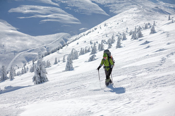 Fototapeta na wymiar Backpacker woman is walking in winter mountains on sunny day