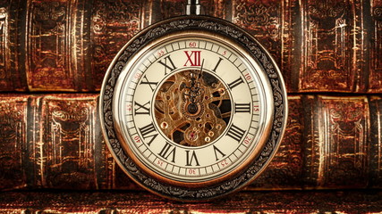 Vintage antique pocket watch against the background of old books