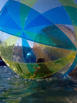 a child inside a zorbing water ball