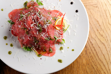 Fine dining, Beef carpaccio with pesto genovese, parmesan cheese, capers and rocket salad