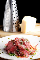 Fine dining, Beef carpaccio with pesto genovese, parmesan cheese, capers and rocket salad