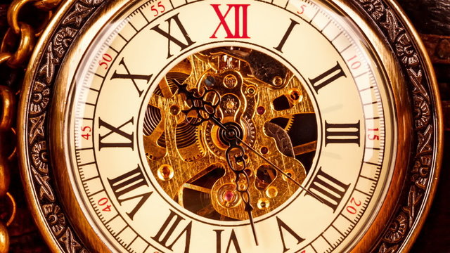 Vintage antique pocket watch against the background of old books