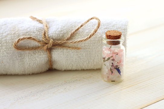 Bottle of herbal aromatic bath salt sugar scrub organic skincare, towel background, soft light, soft focus