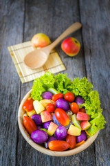 Fresh vegetable salad on wooden background.