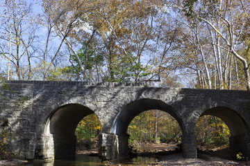 old stone bridge over a stream in a forest