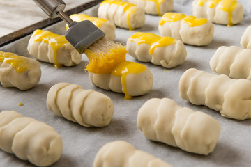 Spennellatura  dei cannoncini di pasta sfoglia prima della cottura in forno