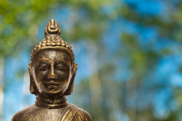 Buddha mit unscharfen Bäumen