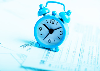 Fototapeta na wymiar Alarm clock and tax forms