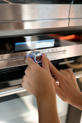 Hand moving the timer knob on the  oven