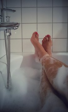 Mann mit lackierten N&auml;gel in Badewanne
