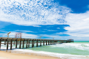Long bridge on the beach with blue sky