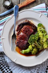 Grilled ribeye steak with boiled broccoli in olive oil and sea salt