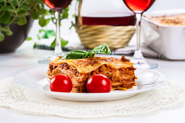 Piece of tasty hot lasagna with red wine..