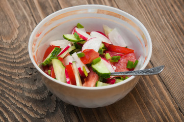 salad in a plate on a brown wooden background