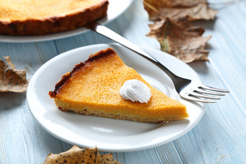 Tasty pumpkin pie in bowl on a blue wooden table
