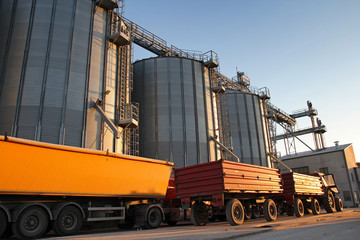 Tractor and Truck Beside Grain Silos