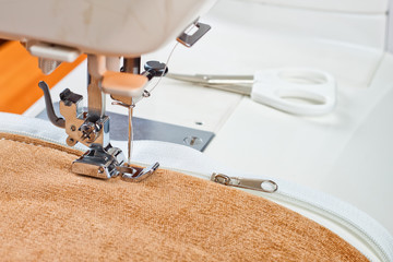 special presser foot of modern sewing machine and zipper. sewing process close up.	