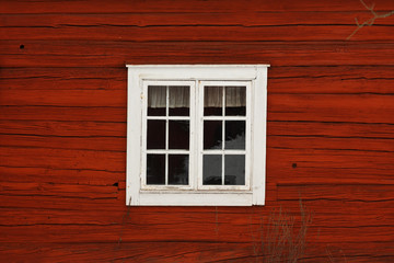 Fototapeta na wymiar Old-fashioned cottage painted in swedish traditional red color.