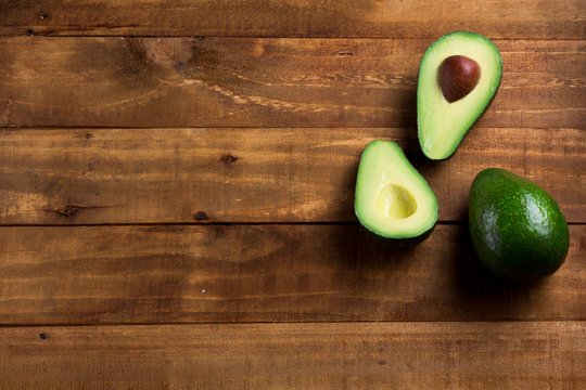 Background fresh avocado on the dark wooden table