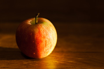 apple on table illuminated by afternoon sunlight