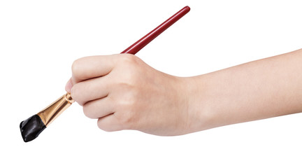 hand holds artistic flat paintbrush with black tip