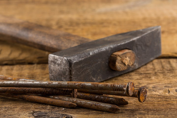 Vintage hammer with nails on wood background