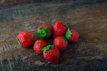 Fragole rosse su tavolo antico sfondo legno, frutta fresca di stagione autunnale