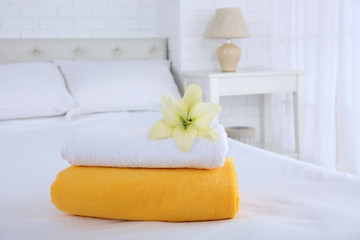 Freshly laundered fluffy towels in bedroom interior