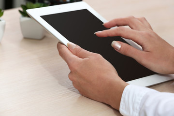 Woman using digital tablet on workplace close up