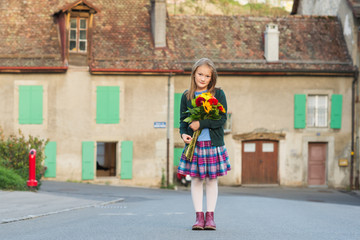 Fototapeta premium Outdoor portrait of a cute little girl with beautiful bouquet of flowers