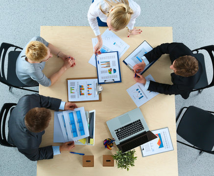 Top view of office workers sitting at a table for meetin