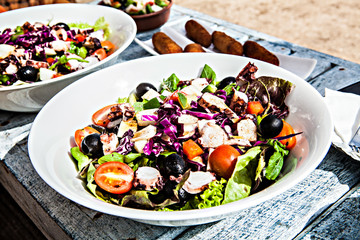 White plate of delicious vegetable salad on wooden table.Tasty