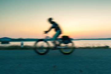 Fototapeta premium motion blurred. Male cyclist cycling on path cycling in public park thailand in the morning refreshing,Cyclist ride the bike exercise on nature concept.
