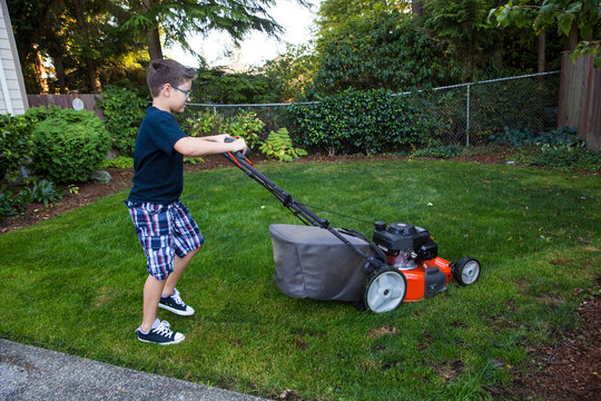 Young boy mowing the lawn